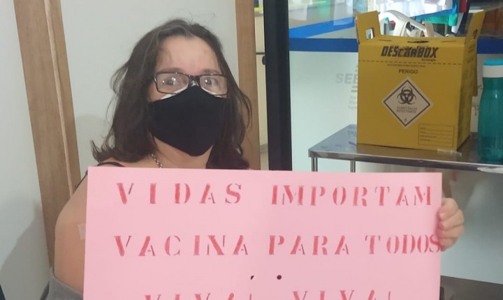 Moradora da capital faz protesto positivo ao tomar a primeira dose